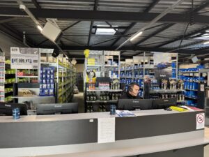 Romain Testard à l’accueil du magasin VT95. Derrière lui, un stock de plus de 1 200 références. ©VT95