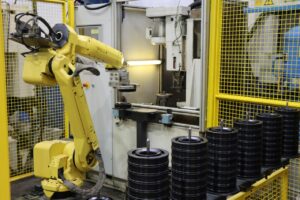 Un robot introduit une poulie dans une machine de sertissage d'IJS.